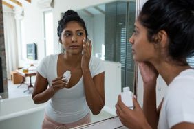 woman applying sunscreen to face