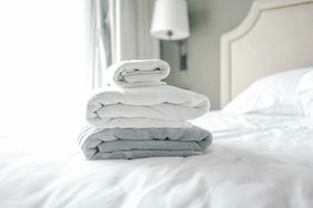 stack of light colored towels on bed