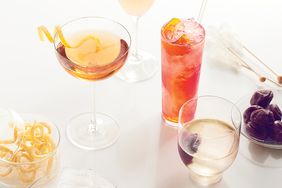 multiple cocktails in various shaped glasses on white surface