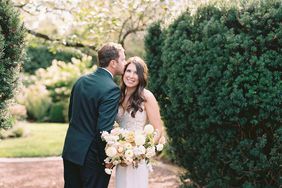 bride smiling while groom kisses her forehead