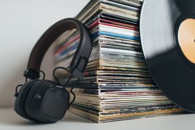 Close up of headphones and stack of vinyl records.