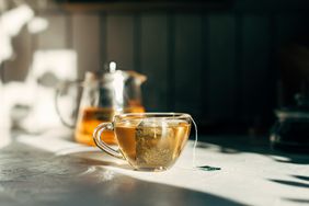 Cup of tea with tea bag on a gray background.