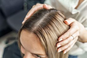 woman in salon chair having hair parted