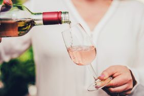 Woman pouring wine in glass.