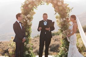 bride and groom during wedding ceremony outside under floral arch