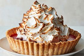 lemon cranberry meringue pie on table with white tablecloth