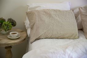 beige linen bedsheets and night table