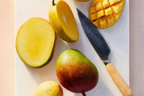 sliced mangoes on cutting board with knife