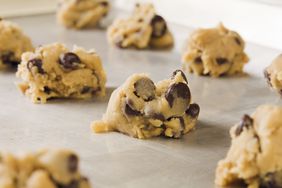 Rows of chocolate chip cookie dough on a cookie sheet