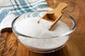 Sugar in glass bowl with wooden spoon