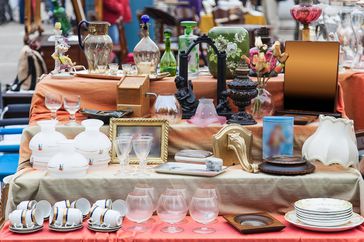 thrift store display table with dishes and objects