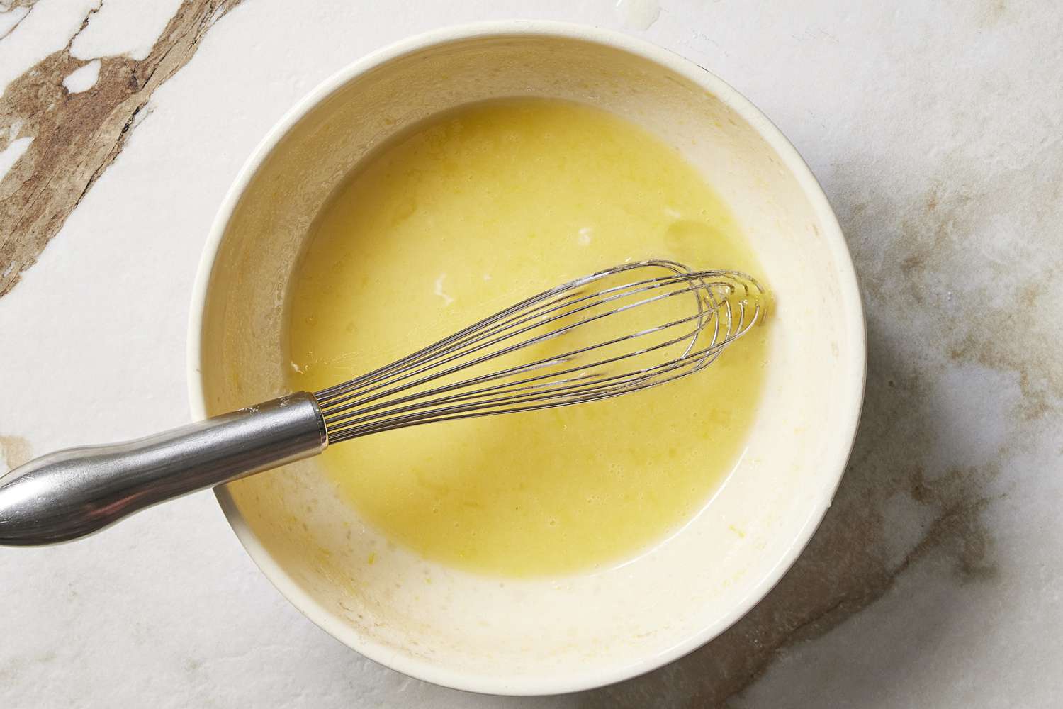 Wet ingredients in a bowl with whisk