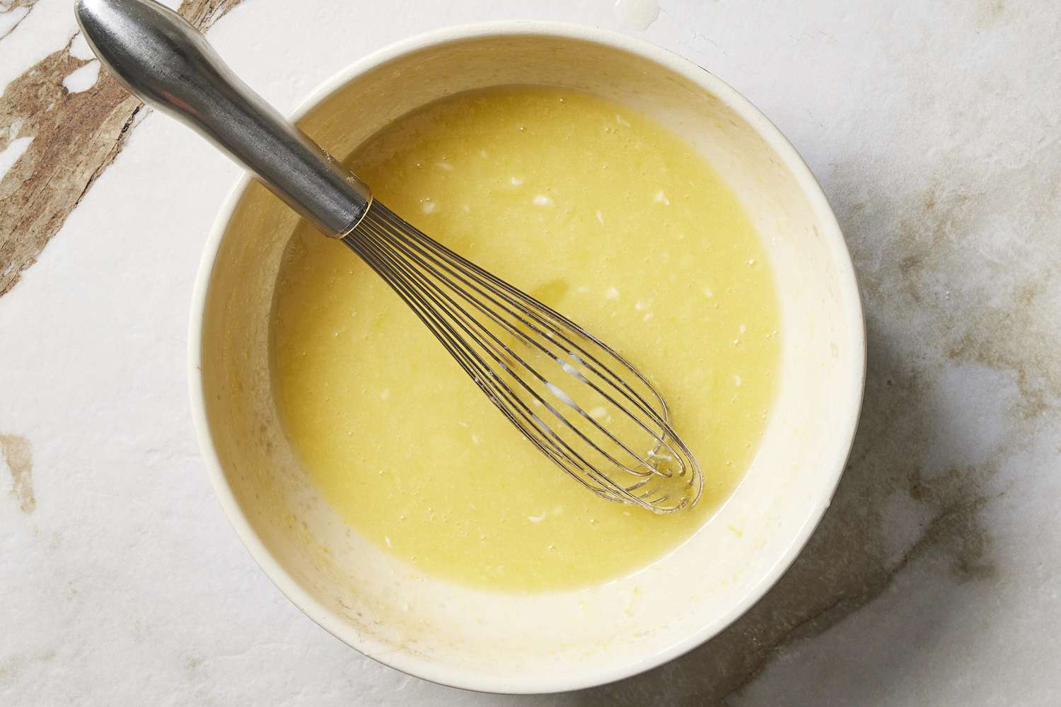 Wet ingredients in bowl with whisk